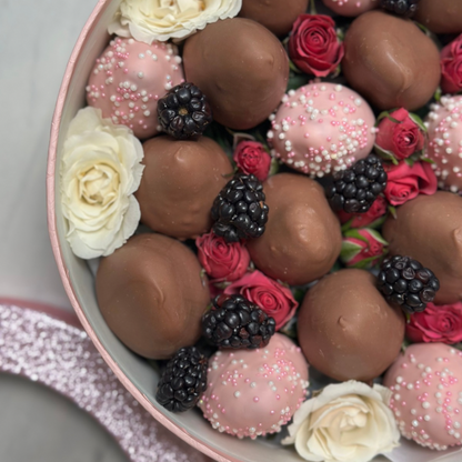 Caja mediana de fresas cubiertas de chocolate de leche y blanco con flores y moras